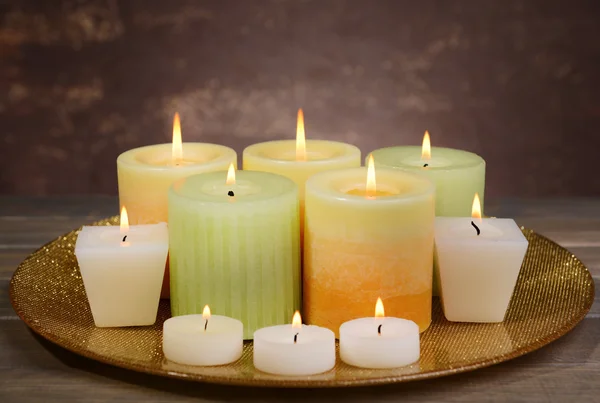 Hermosas velas en la mesa sobre fondo marrón — Foto de Stock