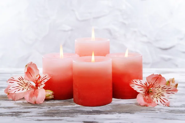 Lindas velas com flores na mesa em fundo cinza — Fotografia de Stock