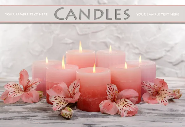 Beautiful candles with flowers on table on grey background — Stock Photo, Image