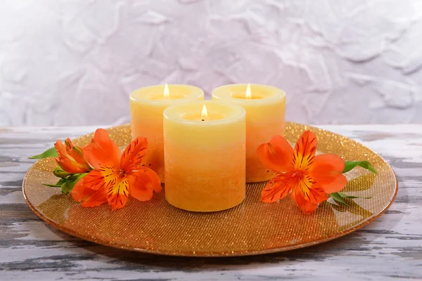 Vackert ljus med blommor på bordet på grå bakgrund — Stockfoto