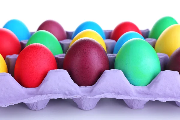 Uova di Pasqua variopinte in vassoio isolato su bianco — Foto Stock