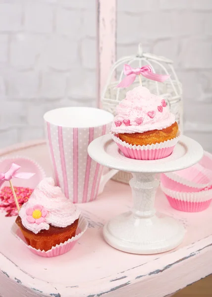 Sabrosos pasteles de taza con crema en silla de madera — Foto de Stock