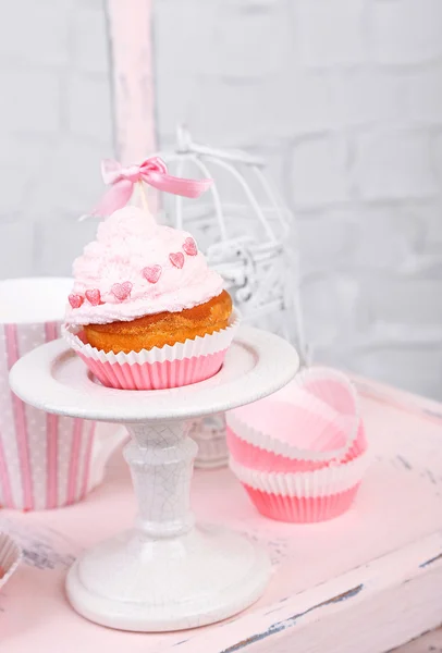 Sabroso pastel de taza con crema en silla de madera — Foto de Stock