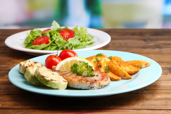 Bife grelhado, legumes grelhados e salada verde fresca na mesa, no fundo brilhante — Fotografia de Stock