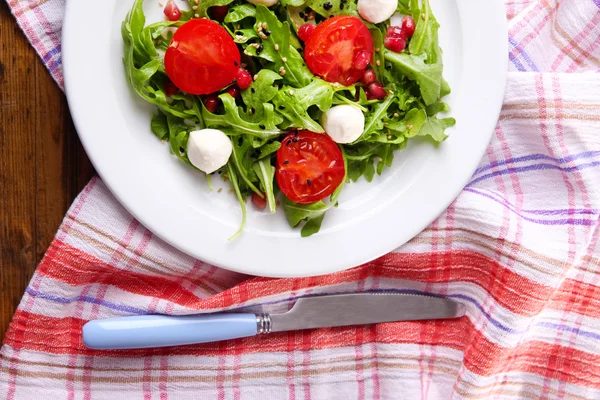 Roka, domates, peynir mozzarella toplar ve ahşap zemin üzerinde plaka üzerinde susam ile yapılan yeşil salata — Stok fotoğraf