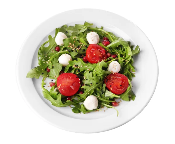 Green salad made with  arugula, tomatoes, cheese mozzarella balls and sesame  on plate, isolated on white — Stock Photo, Image