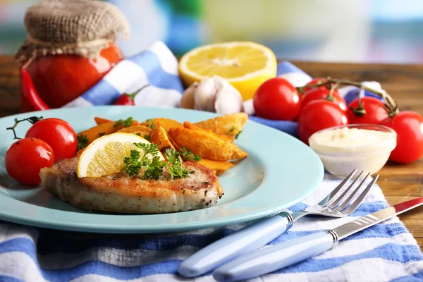 Стейк на гриле, овощи на гриле и кусочки жареного картофеля на столе, на ярком фоне — стоковое фото