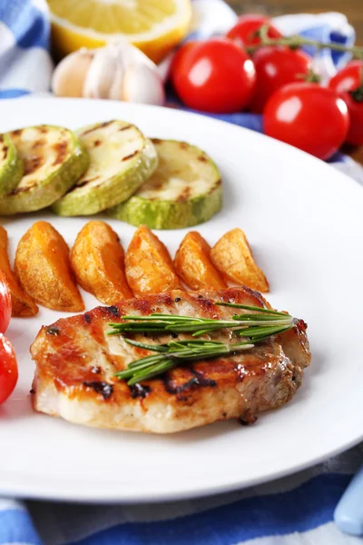 Grilled steak, grilled vegetables and fried potato pieces on table background — Stock Photo, Image