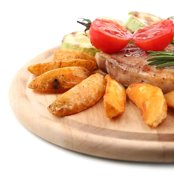 Bistecca alla griglia con pezzi di patate fritte e verdure alla griglia su tavola di legno, isolata su bianco — Foto Stock