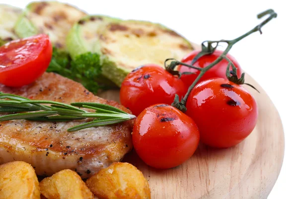 Bife grelhado com pedaços de batata frita e legumes grelhados em tábua de madeira, isolado em branco — Fotografia de Stock