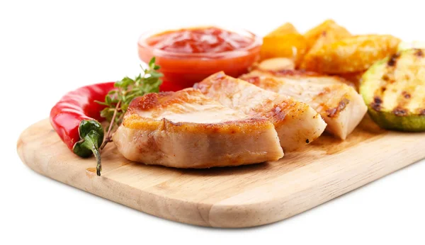 Filete a la parrilla con trozos de patata frita y verduras a la parrilla sobre tabla de madera, aislado en blanco —  Fotos de Stock