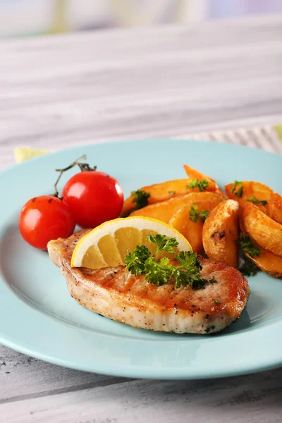 Grilled steak, grilled vegetables and fried potato pieces on table, on bright background — Stock Photo, Image