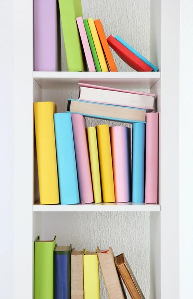 Books on white shelves close-up — Stock Photo, Image