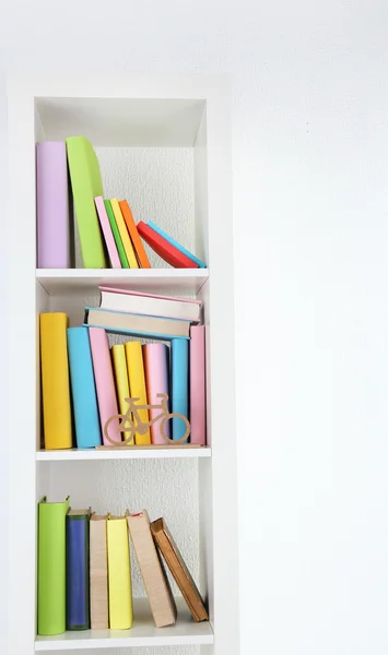 Livros em prateleiras brancas no quarto — Fotografia de Stock