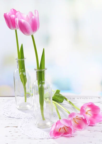 Mooie tulpen in emmer in vaas op tafel op lichte achtergrond — Stockfoto