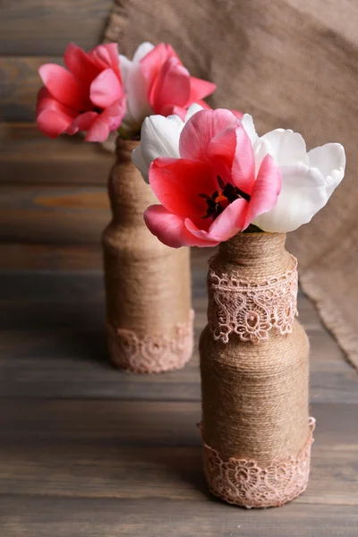 Belles tulipes dans seau en vase sur table sur fond gris — Photo