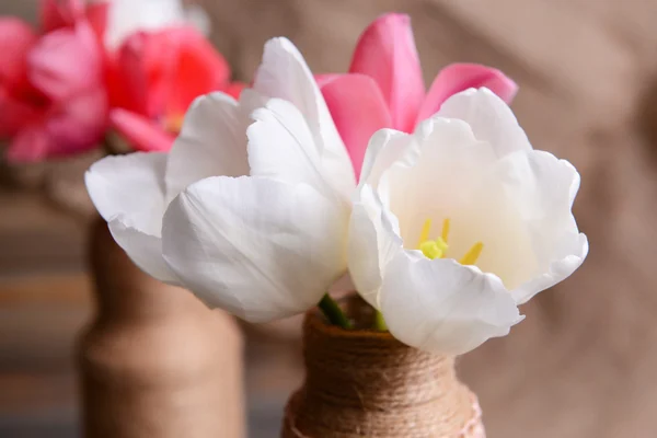 Schöne Tulpen im Eimer in der Vase auf dem Tisch auf grauem Hintergrund — Stockfoto