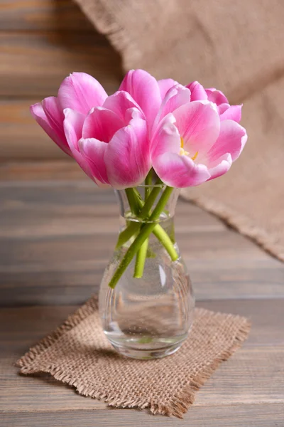 Красивые тюльпаны в ведре в вазе на столе на сером фоне — стоковое фото