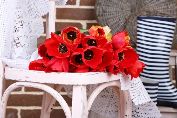 Kytice barevné tulipány na židli, na domácí interiér pozadí — Stock fotografie