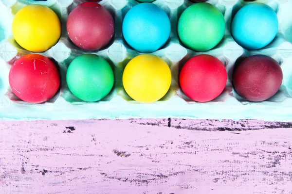 Ovos de Páscoa coloridos na bandeja em fundo de madeira — Fotografia de Stock