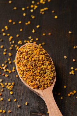 ahşap zemin üzerine kaşık içinde baharat polen