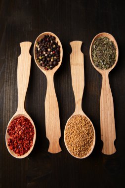 Ahşap zemin üzerine kaşık farklı baharatlar