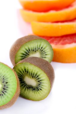 Greyfurt ve kivi meyve dilimleri üzerinde beyaz izole