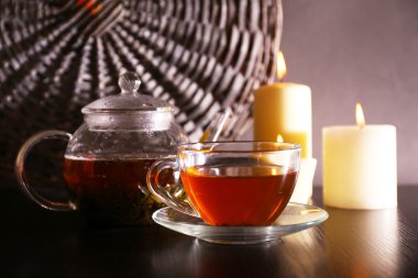 Çay cam çaydanlık ve tablo, koyu arka plan üzerinde mum ile kompozisyon