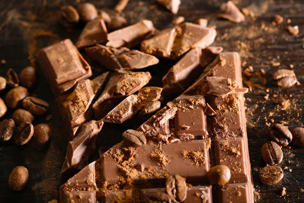 Chopped bar of chocolate on wooden background — Stock Photo, Image