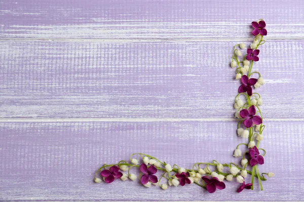 Hermosas flores y lirios lila del valle, sobre fondo de madera — Foto de Stock