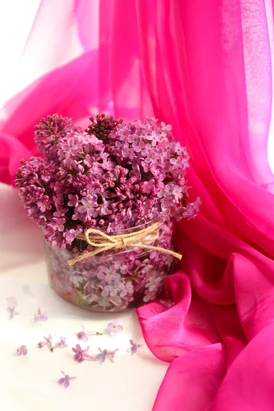 Beautiful lilac flowers in glass jar — Stock Photo, Image