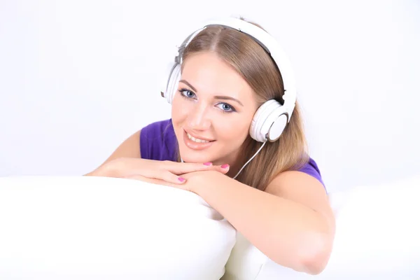 Jong meisje luisteren naar muziek op huis interieur achtergrond — Stockfoto