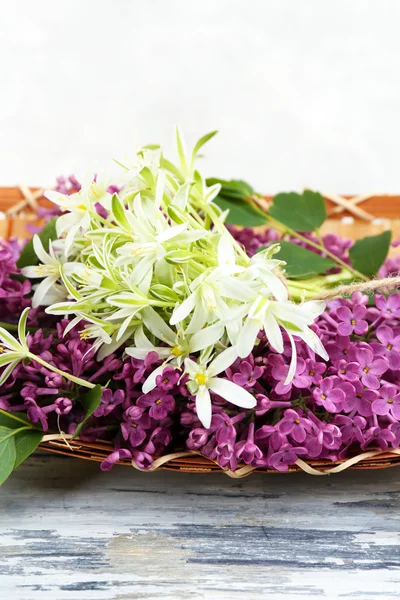 Lindas flores de primavera em cesta de vime na mesa de madeira, close-up — Fotografia de Stock