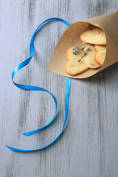 Galletas de lavanda en bolsa de papel, sobre fondo de madera de color —  Fotos de Stock