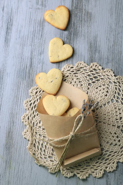 Soubory cookie levandule v papírové tašce, na barevné dřevěné pozadí — Stock fotografie