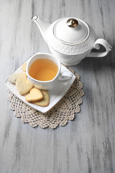 Biscotti di lavanda e tazza di tè saporito su sfondo di legno a colori — Foto Stock