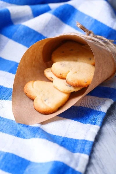 Soubory cookie levandule v papírové tašce, na barevný ubrousek pozadí — Stock fotografie