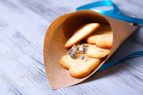 Лавандовое печенье в бумажном пакете, на фоне цвета дерева — стоковое фото