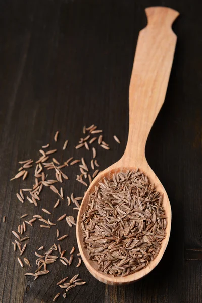 Épice cumin dans la cuillère sur fond en bois — Photo