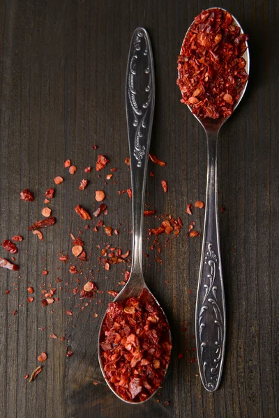 Spice pepper in spoons on wooden background — Stock Photo, Image