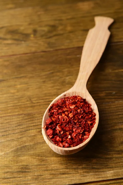 Spice pepper in spoon on wooden background — Stock Photo, Image