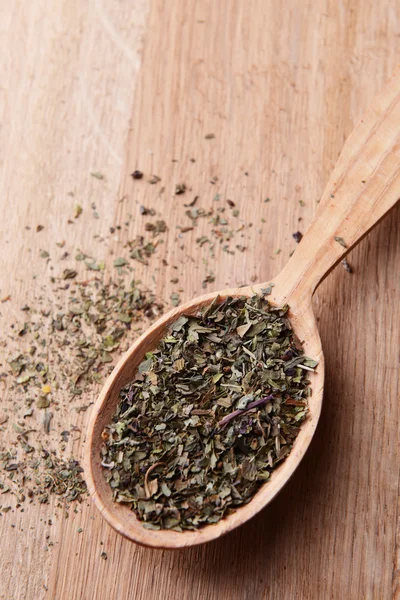 Spice greens in spoon on wooden background — Stock Photo, Image