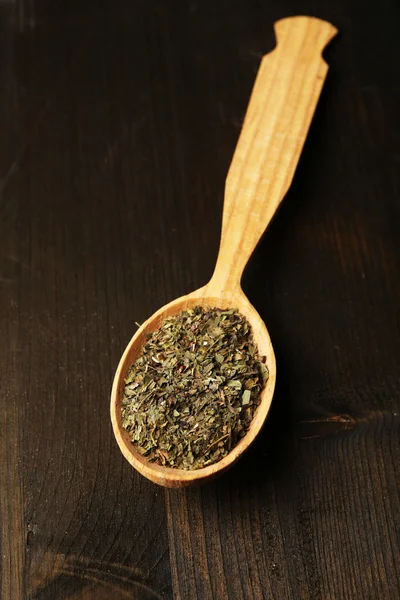 Spice greens in spoon on wooden background — Stock Photo, Image