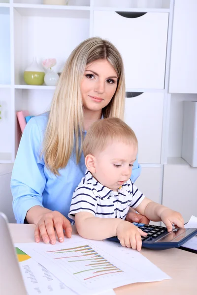 Bella donna con bambino che lavora a casa — Foto Stock