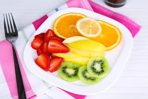 Various sliced fruits on plate on table close-up — Stock Photo, Image