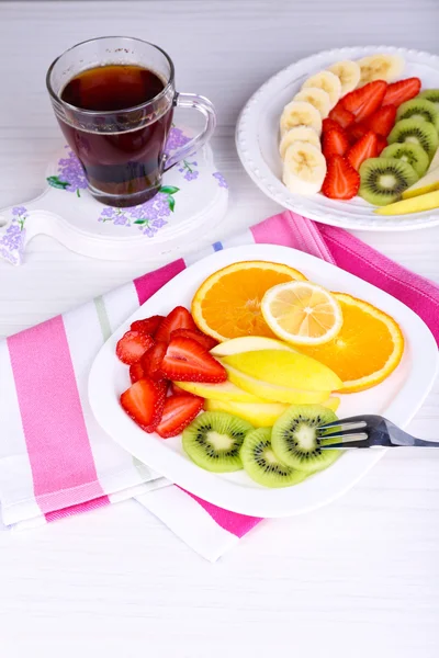 Various sliced fruits on plates on table close-up — Stock Photo, Image