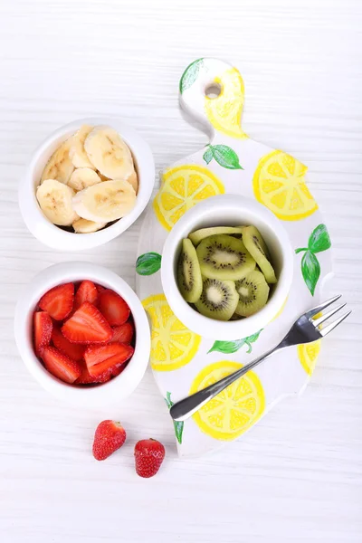 Různé krájeného ovoce v miskách na tabulka detail — Stock fotografie