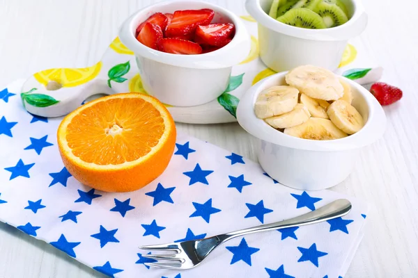 Vários frutos cortados em tigelas na mesa close-up — Fotografia de Stock