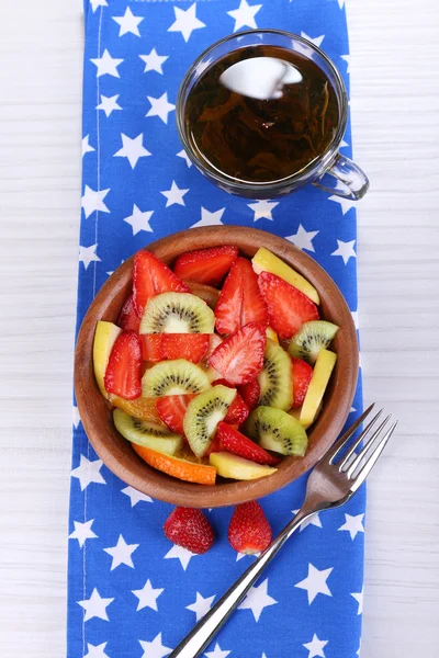 Различные нарезанные фрукты в миске на столе крупным планом — стоковое фото