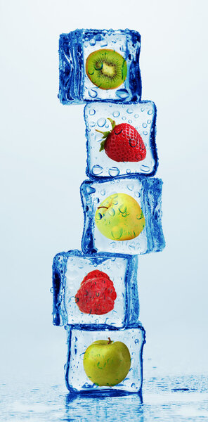 Ice cubes with fruits and berries on light background